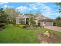 Inviting home exterior with well-maintained lawn, mature trees, and a paver driveway at 3633 Cordgrass Dr, Valrico, FL 33596