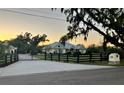 Exterior shot of home featuring a gated driveway with black fencing and lush landscape at 3709 Gallagher Rd, Plant City, FL 33565