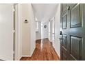 Bright hallway showcasing hardwood floors, neutral paint, thermostat, and entry door with digital lock at 402 S Armenia Ave # 137, Tampa, FL 33609