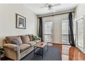 Bright living room with hardwood floors, neutral paint, ceiling fan, large windows and comfortable sofa at 402 S Armenia Ave # 137, Tampa, FL 33609
