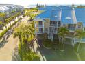 Exterior aerial view of a three story waterfront condo with balconies, tropical landscaping, and covered parking at 418 Bahia Beach Blvd, Ruskin, FL 33570