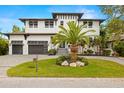 Beautiful two-story modern home featuring a well-manicured lawn, a palm tree, and a two-car garage at 4806 W San Rafael St, Tampa, FL 33629