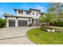 Beautiful two-story modern home featuring a well-manicured lawn, a palm tree, and a two-car garage at 4806 W San Rafael St, Tampa, FL 33629