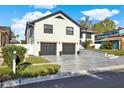 Charming two-story home featuring a modern gray driveway, two-car garage, and well-manicured lawn at 4954 Cardinal Trl, Palm Harbor, FL 34683