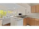 Cozy kitchen with granite countertops, a breakfast bar, wooden cabinets, and stainless dishwasher at 5125 Palm Springs Blvd # 11306, Tampa, FL 33647