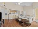 Open-concept living room with hardwood floors, ceiling fan, breakfast bar, and sliding door access at 5125 Palm Springs Blvd # 11306, Tampa, FL 33647