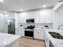 Bright kitchen featuring white cabinets, stainless steel appliances, and quartz countertops at 7862 Sailboat Key S Blvd # 103, South Pasadena, FL 33707