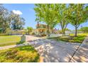 Charming two-story home with a manicured lawn, white picket fence, and mature trees creating a picturesque curb appeal at 8205 Overlook Ne Pl, St Petersburg, FL 33702