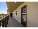 Hallway to unit, featuring a secure front door, railing and serene views of the surrounding landscape at 9860 62Nd N Ter # 1051, St Petersburg, FL 33708