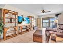 Cozy living room with tile floors, rattan shelving, ceiling fan, and sliding doors to outside at 10301 Gulf Blvd # 302, Treasure Island, FL 33706