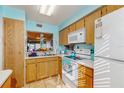 Cozy kitchen with light wood cabinets and white appliances, offering functionality at 11135 Carriage Hill Dr # 5, Port Richey, FL 34668
