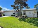 Lovely single-story home with a lush green lawn and attached two car garage at 14305 Tennyson Dr, Hudson, FL 34667