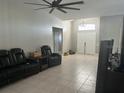 Spacious living room with tile flooring, a ceiling fan, and comfortable leather furniture at 14305 Tennyson Dr, Hudson, FL 34667
