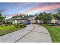 Charming single-story home boasts a well-manicured lawn, mature trees, and a circular driveway at 16808 Woburn Ln, Lutz, FL 33549