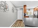 Hallway view with wood floors near kitchen, entryway door, and gray walls at 19029 Us Highway 19 N # 27E, Clearwater, FL 33764