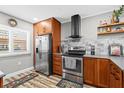 Modern kitchen with stainless steel appliances, wooden cabinets, and a stylish range hood at 19029 Us Highway 19 N # 27E, Clearwater, FL 33764