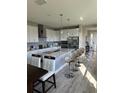Bright, modern kitchen features white cabinets, stainless steel appliances, an island, and stylish bar stools at 1904 146Th E Ter, Parrish, FL 34219