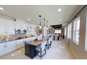 Open-concept kitchen boasts white cabinetry, granite countertops, a dark island, and a seamless flow to the dining area at 1904 146Th E Ter, Parrish, FL 34219