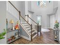 Welcoming foyer with staircase, high ceilings, decorative chandelier, wood-look flooring, and light gray walls at 19412 Lonesome Pine Dr, Land O Lakes, FL 34638