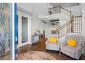 Entryway featuring a staircase, arched entryways, wood-look flooring, gray walls, and armchairs at 19412 Lonesome Pine Dr, Land O Lakes, FL 34638