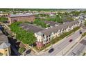 Bird's eye view of the yellow condo building with balconies, landscaping, and nearby commercial areas at 2010 E Palm Ave # 15210, Tampa, FL 33605