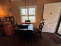Cozy dining area featuring dark wood table and chairs with natural light from a window at 20857 Haulover Cv # 1, Lutz, FL 33558