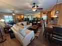 Open living area with comfortable seating, ceiling fan, and mirrored wall for an expanded feel at 20857 Haulover Cv # 1, Lutz, FL 33558
