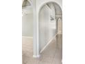 Bright hallway with neutral tile flooring and decorative arches leading into the main living area at 24941 Ravello St, Land O Lakes, FL 34639