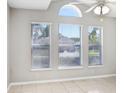 Sunlit living room boasting a ceiling fan and three large windows, creating a bright and airy atmosphere at 24941 Ravello St, Land O Lakes, FL 34639