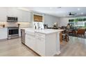 Bright, modern kitchen featuring a large center island with a farmhouse sink at 2516 Leafwing Ct, Palm Harbor, FL 34683