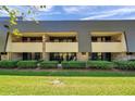 Two story condo building with brick and siding exterior and well manicured lawn at 36750 Us 19 N # 2763, Palm Harbor, FL 34684
