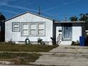 Close exterior of home with blue trim, featuring a neat front yard and a hose, showcasing curb appeal at 4005 Sunrise S Dr, St Petersburg, FL 33705