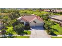 Beautiful home featuring lush landscaping, a red tile roof, a well-manicured lawn, and an attached two-car garage at 4499 Chase Oaks Dr, Sarasota, FL 34241