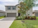 Two-story home featuring a well-maintained front yard and a two-car garage at 5210 Dandelion St, Apollo Beach, FL 33572