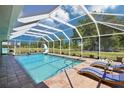 Relaxing screened-in pool with lounge chairs on the brick patio at 6418 Austrian Blvd, Punta Gorda, FL 33982