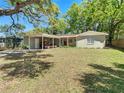 Attractive single-story home with a carport, mature shade trees, and a neat front lawn at 7303 N Branch Ave, Tampa, FL 33604