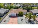 Aerial view of a home with a well-maintained yard and a driveway; the property is situated in a friendly neighborhood at 7330 Cherry Laurel Dr, Port Richey, FL 34668