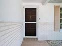 Close-up of a front door with unique carvings in a white brick wall at 7330 Cherry Laurel Dr, Port Richey, FL 34668