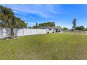 Beautifully landscaped front yard with vibrant green grass, a sturdy white fence, and tropical palm trees adding to the curb appeal at 7401 35Th N Ave, St Petersburg, FL 33710