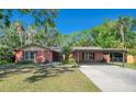 Charming brick home with a well-maintained lawn, mature trees, and a covered carport providing ample parking space at 8136 Honeybee Ln, Tampa, FL 33635