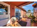 Inviting front porch with a bench seat, tiled floor and potted plants at 10035 Cherry Creek Ln, Port Richey, FL 34668