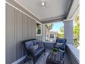 Cozy, covered front porch with wicker furniture, throw pillows, and a small table at 1010 8Th S Ave, St Petersburg, FL 33705
