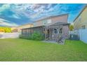 Spacious backyard features an open lawn, wood pergola, screened porch, and fenced perimeter at 11118 Golden Silence Dr, Riverview, FL 33579
