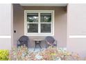 Cozy front porch features a table and chairs and a beautifully landscaped yard at 11118 Golden Silence Dr, Riverview, FL 33579