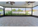 This screened-in patio features ceiling fans and views of the backyard landscaping at 11118 Golden Silence Dr, Riverview, FL 33579