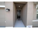 A welcoming, covered entrance with a stylish black front door and modern lighting at 11517 Koti Creek Ln, Thonotosassa, FL 33592