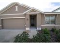 Inviting home exterior featuring a two-car garage and a cozy, covered entrance at 11517 Koti Creek Ln, Thonotosassa, FL 33592