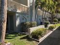 Condo exterior showcasing tropical landscaping with multiple stories and walkway at 11720 Park Blvd # 104, Seminole, FL 33772