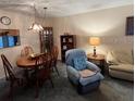 Cozy living room with dining table, comfy armchair, and built-in shelving unit at 11720 Park Blvd # 104, Seminole, FL 33772