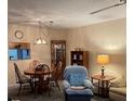 Cozy living room with dining table, comfy armchair, and built-in shelving unit at 11720 Park Blvd # 104, Seminole, FL 33772